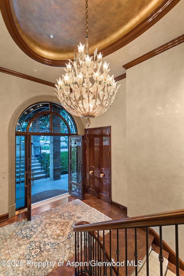 64 Pitkin Way, Aspen, CO 81611 - foyer entrance with wood finished floors, a tray ceiling, an inviting chandelier, and crown molding