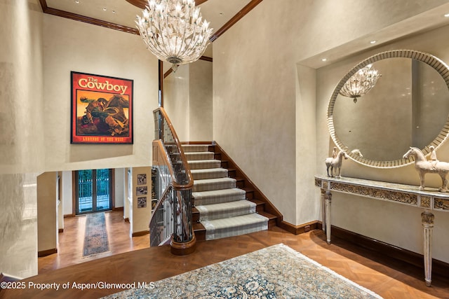 64 Pitkin Way, Aspen, CO 81611 - stairway featuring baseboards, a towering ceiling, a notable chandelier, and crown molding