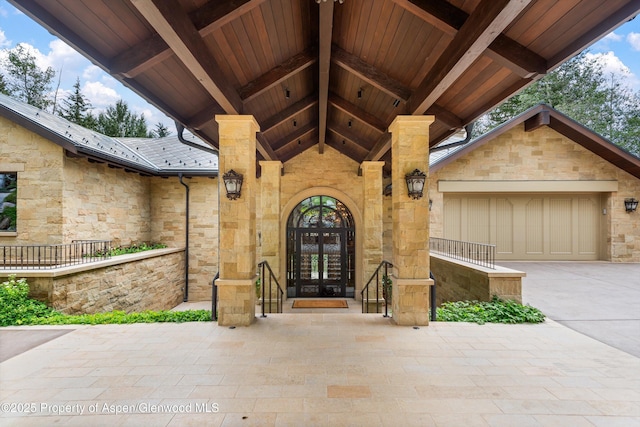 64 Pitkin Way, Aspen, CO 81611 - view of exterior entry featuring a garage, french doors, driveway, and stone siding