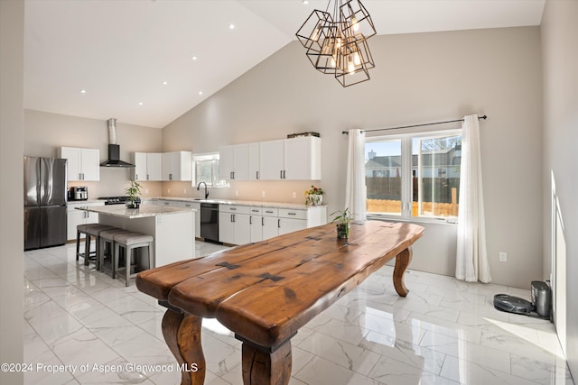 kitchen featuring a center island, high vaulted ceiling, white cabinets, black dishwasher, and stainless steel refrigerator