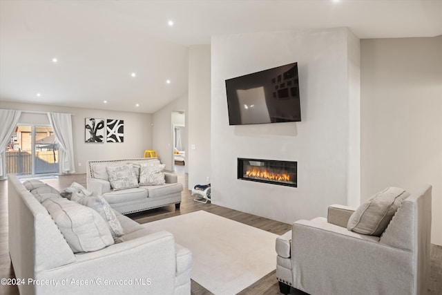 living room with hardwood / wood-style flooring and vaulted ceiling