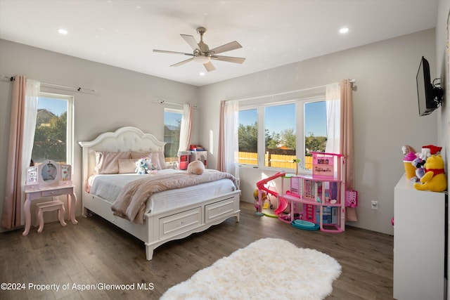 bedroom featuring ceiling fan, dark wood-type flooring, and multiple windows