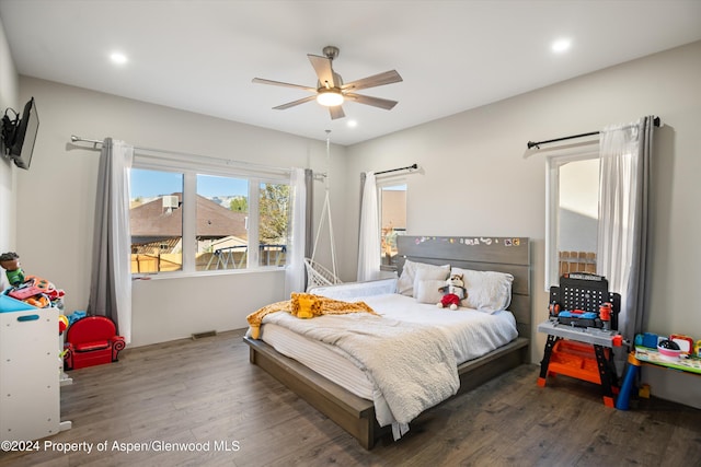 bedroom with dark hardwood / wood-style flooring and ceiling fan