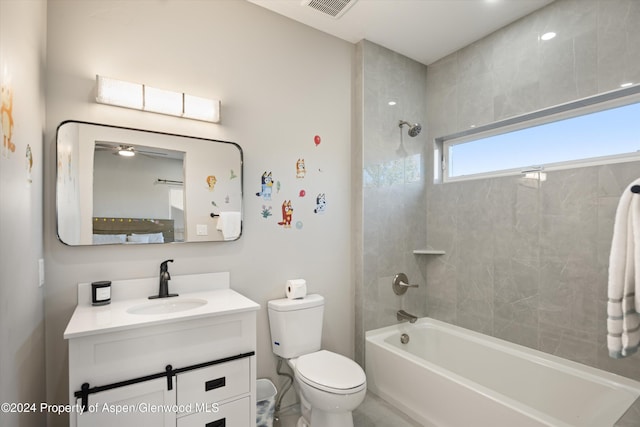 full bathroom with tiled shower / bath combo, ceiling fan, toilet, and vanity