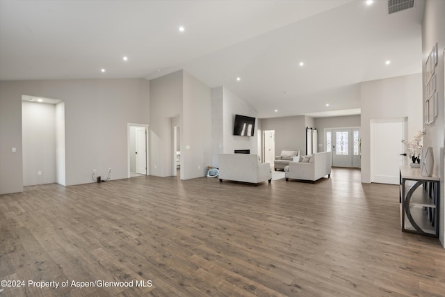 unfurnished living room featuring hardwood / wood-style flooring, a large fireplace, and high vaulted ceiling