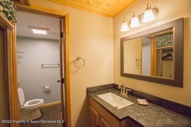 bathroom featuring vanity, toilet, and wood ceiling