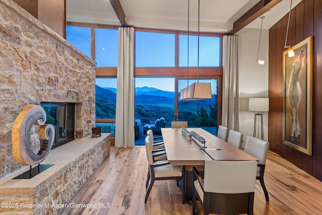1000 Lazy O Rd, Snowmass, CO 81654 - dining room featuring a mountain view, a fireplace, a high ceiling, and hardwood / wood-style flooring