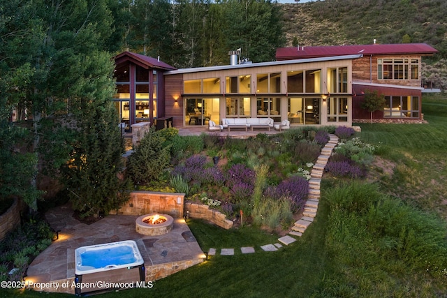 1000 Lazy O Rd, Snowmass, CO 81654 - rear view of house featuring a patio, an outdoor living space with a fire pit, and a lawn