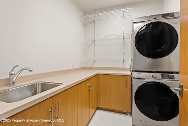 1000 Lazy O Rd, Snowmass, CO 81654 - laundry room featuring a sink, light tile patterned floors, stacked washer and clothes dryer, and cabinet space