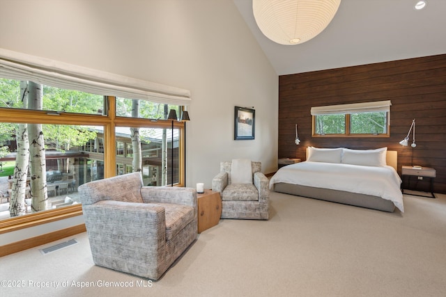 1000 Lazy O Rd, Snowmass, CO 81654 - carpeted bedroom featuring visible vents, wood walls, and high vaulted ceiling