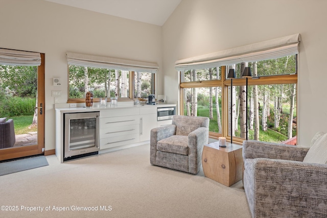 1000 Lazy O Rd, Snowmass, CO 81654 - sitting room featuring wet bar, high vaulted ceiling, beverage cooler, and light colored carpet
