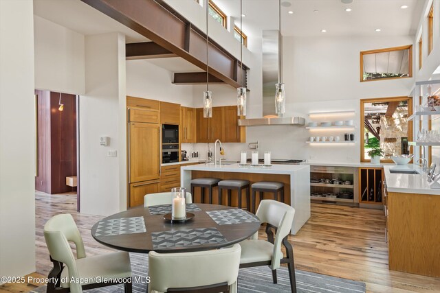 1000 Lazy O Rd, Snowmass, CO 81654 - dining space with indoor bar, recessed lighting, light wood finished floors, and a towering ceiling