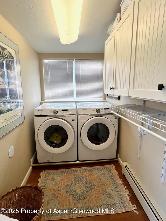 washroom with cabinet space, baseboards, baseboard heating, and washer and clothes dryer