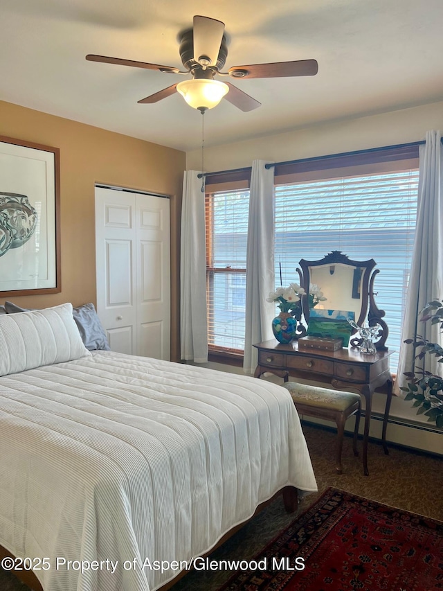 carpeted bedroom with ceiling fan and a closet