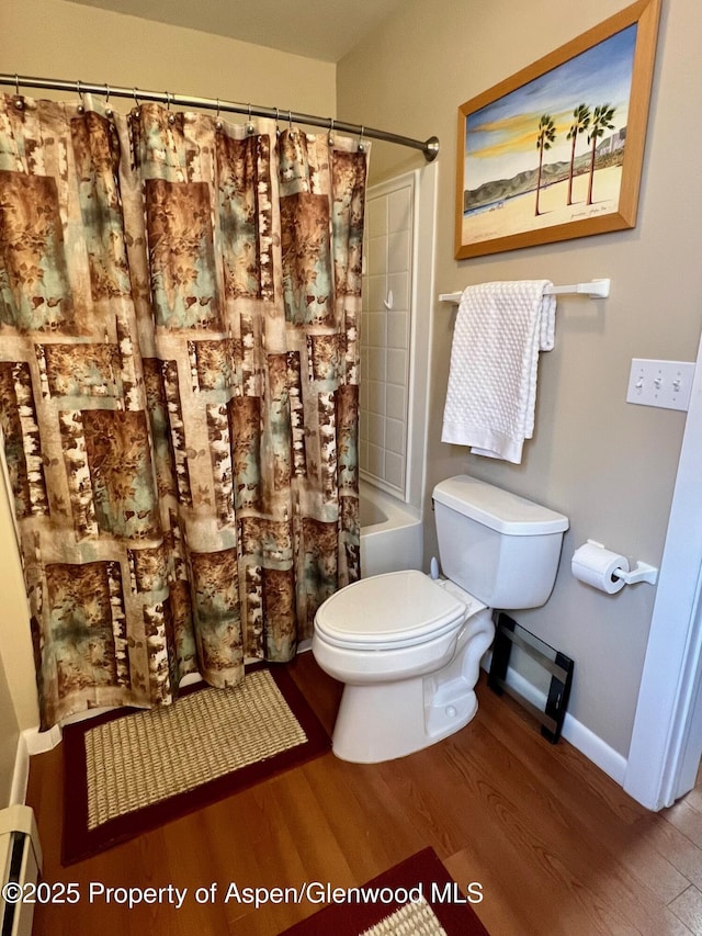 full bath featuring toilet, wood finished floors, shower / bath combo with shower curtain, and baseboards
