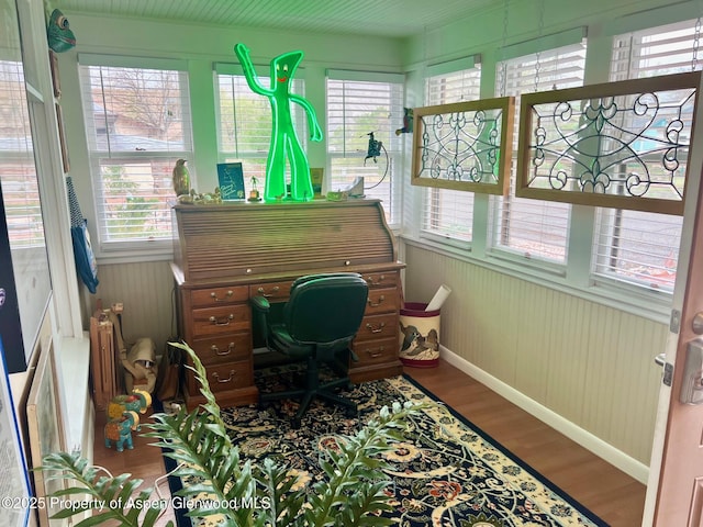 office area featuring baseboards, wood finished floors, and plenty of natural light