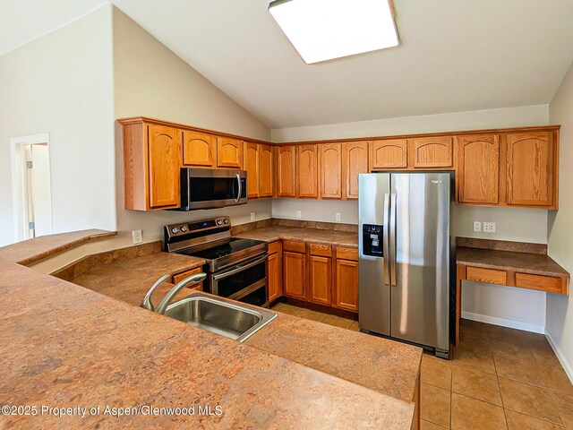 612 Riverview Dr Unit 808, New Castle, CO 81647 - kitchen featuring stainless steel appliances, a sink, vaulted ceiling, light tile patterned flooring, and brown cabinets