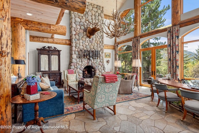 87 Magnifico Dr, Aspen, CO 81611 - living room featuring a high ceiling, stone flooring, a chandelier, a stone fireplace, and recessed lighting