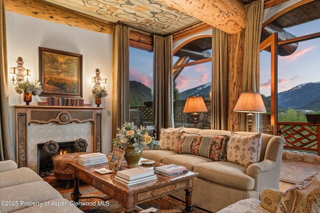 87 Magnifico Dr, Aspen, CO 81611 - living room featuring a mountain view, wood finished floors, a tiled fireplace, and plenty of natural light