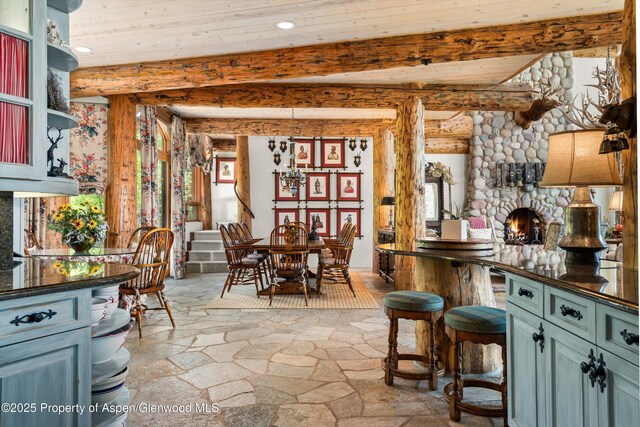 87 Magnifico Dr, Aspen, CO 81611 - kitchen with dark countertops, log walls, stone floors, recessed lighting, and a wooden ceiling with exposed beams
