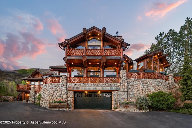 87 Magnifico Dr, Aspen, CO 81611 - view of front of house featuring an attached garage, asphalt driveway, and a balcony