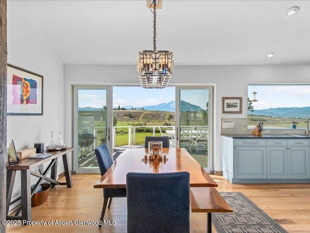 dining space featuring a chandelier, recessed lighting, light wood-style flooring, and a mountain view