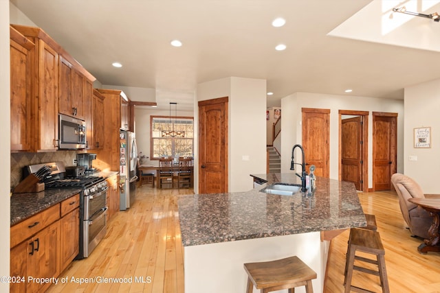 kitchen featuring appliances with stainless steel finishes, sink, a kitchen breakfast bar, and a kitchen island with sink