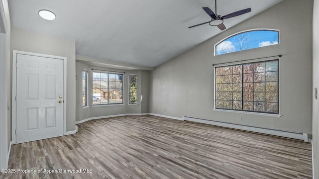 interior space with baseboards, a ceiling fan, lofted ceiling, wood finished floors, and baseboard heating