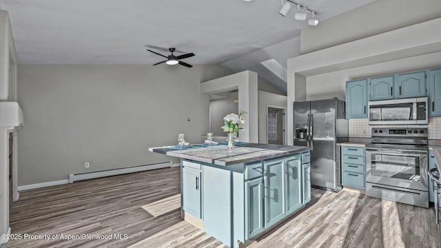 kitchen with tasteful backsplash, a ceiling fan, a baseboard radiator, appliances with stainless steel finishes, and blue cabinets