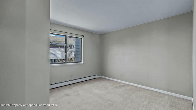 unfurnished room featuring a baseboard heating unit, carpet flooring, and baseboards