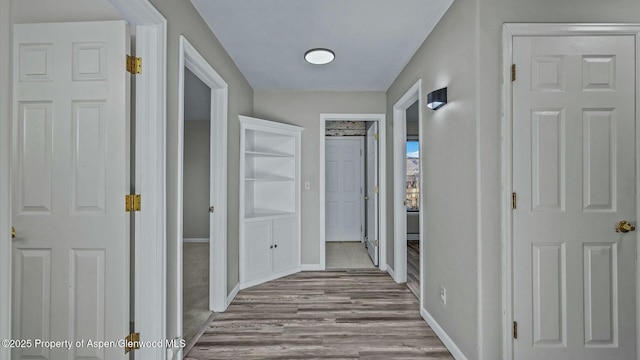 hall with wood finished floors and baseboards