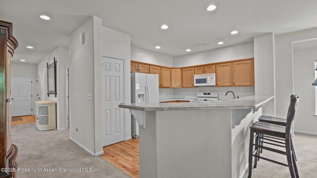 150 Castle Ct, New Castle, CO 81647 - kitchen with white appliances, a kitchen breakfast bar, light countertops, recessed lighting, and light carpet