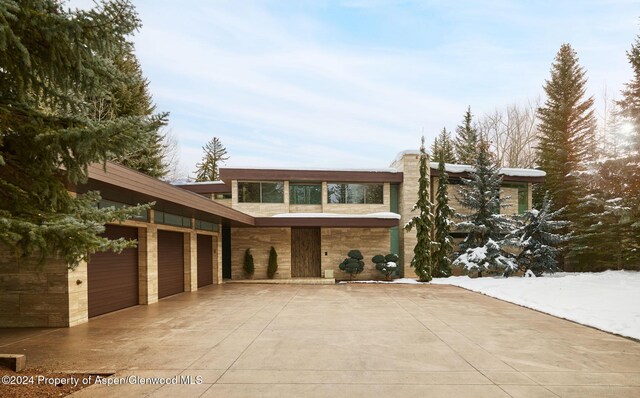 102 Wood Duck Ln, Aspen, CO 81611 - view of front of property featuring driveway, stone siding, and an attached garage