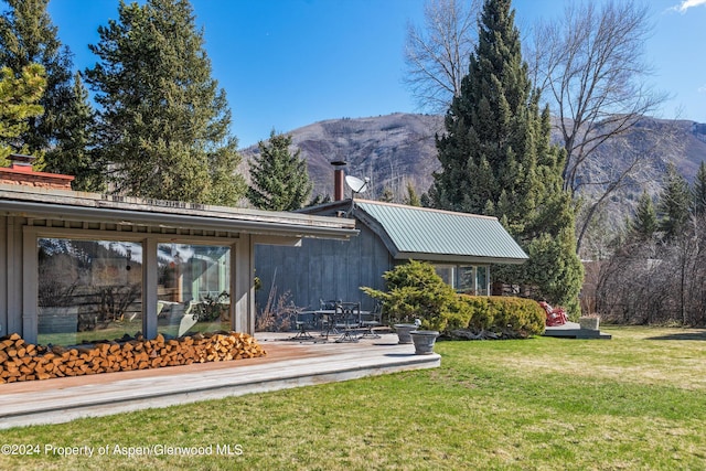 back of house featuring a yard and a mountain view