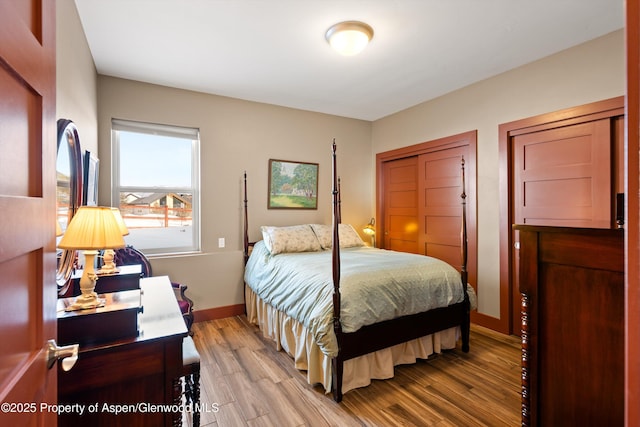 bedroom featuring a closet, wood finished floors, and baseboards