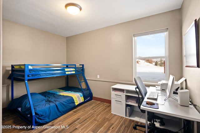 bedroom with baseboards and wood finished floors