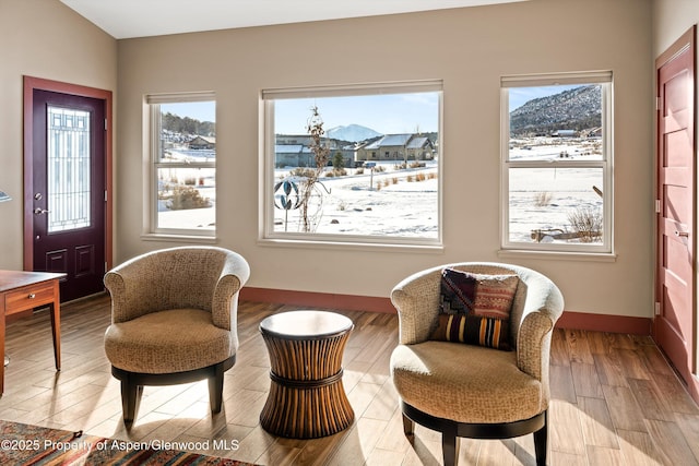 sitting room with a mountain view, baseboards, and wood finished floors