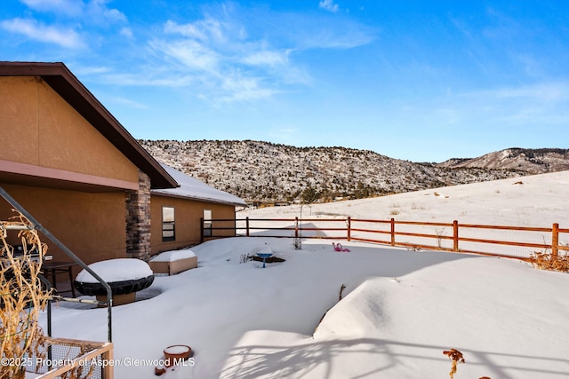 yard layered in snow with fence and a mountain view