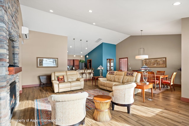 living room with recessed lighting, a stone fireplace, baseboards, and wood finished floors