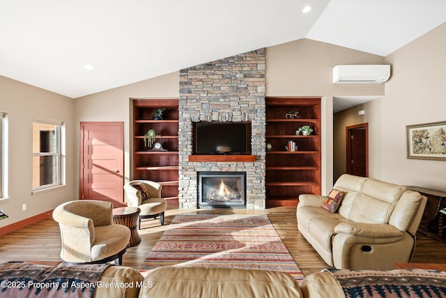 living area with a fireplace, wood finished floors, baseboards, vaulted ceiling, and a wall mounted AC