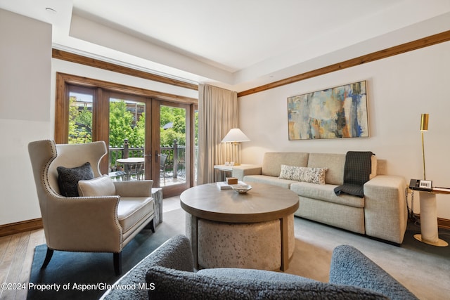 living room featuring hardwood / wood-style floors, crown molding, and french doors