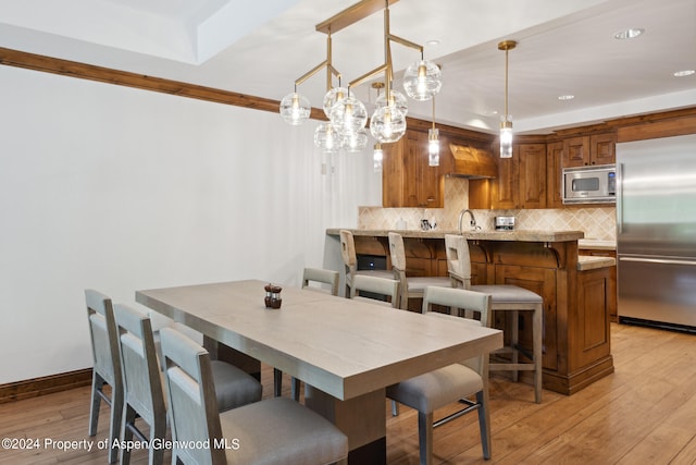 dining room with sink and light wood-type flooring