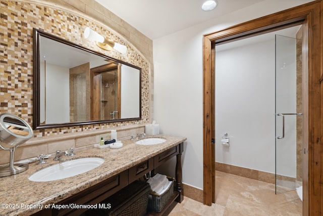 bathroom with vanity, tasteful backsplash, and a shower with door