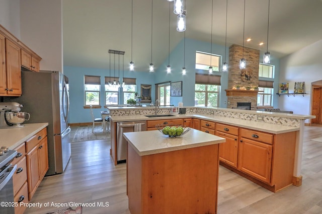 369 N Meadow Dr, Rifle, CO 81650 - kitchen featuring stainless steel appliances, a spacious island, a stone fireplace, a high ceiling, and healthy amount of natural light