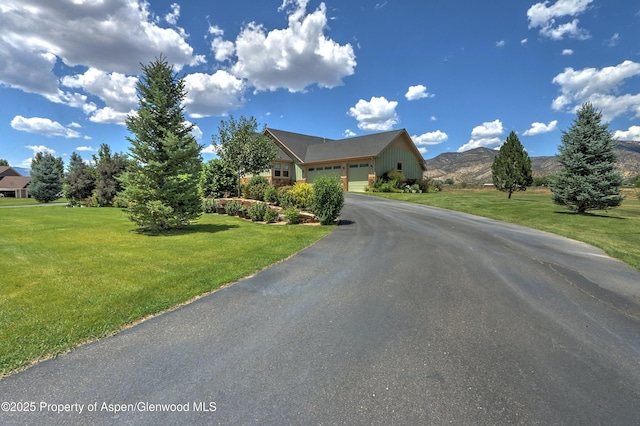 369 N Meadow Dr, Rifle, CO 81650 - view of front of house featuring asphalt driveway, an attached garage, a front lawn, and a mountain view