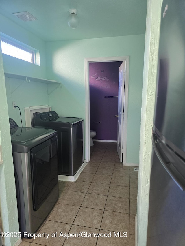 180 E 26th St, Rifle, CO 81650 - laundry room with washing machine and dryer and light tile patterned floors