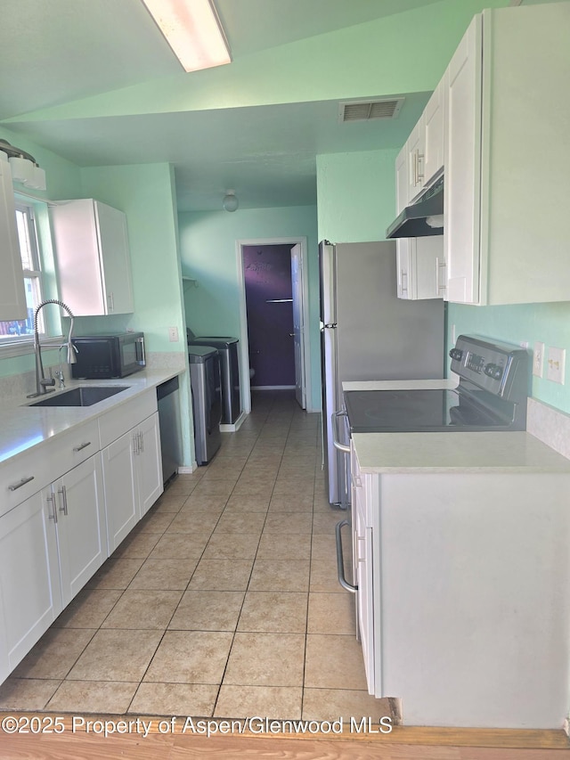 180 E 26th St, Rifle, CO 81650 - kitchen with a sink, under cabinet range hood, white cabinets, and light tile patterned floors