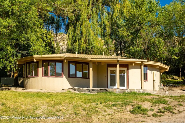 rear view of property with a lawn