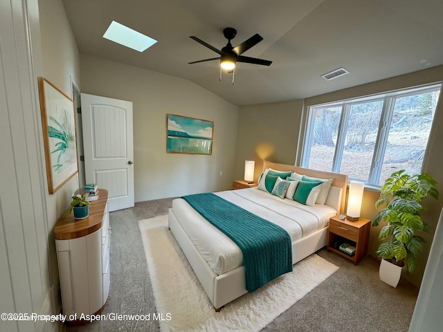 bedroom featuring ceiling fan, light colored carpet, and vaulted ceiling with skylight