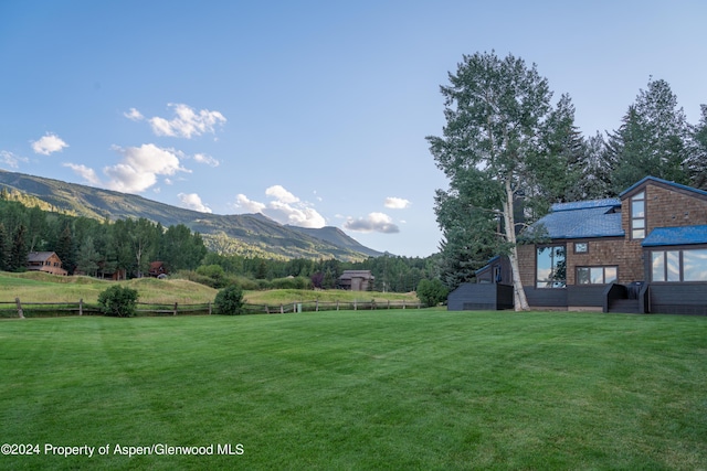 view of yard with fence, a mountain view, and a rural view